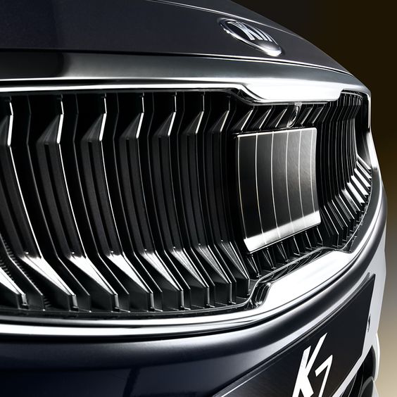 Close-up of a sleek black car grille with chrome detailing, showcasing modern automotive design elements, and a K7 logo.