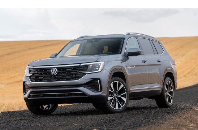 Volkswagen SUV parked on a rural road with a background of fields and a cloudy sky.