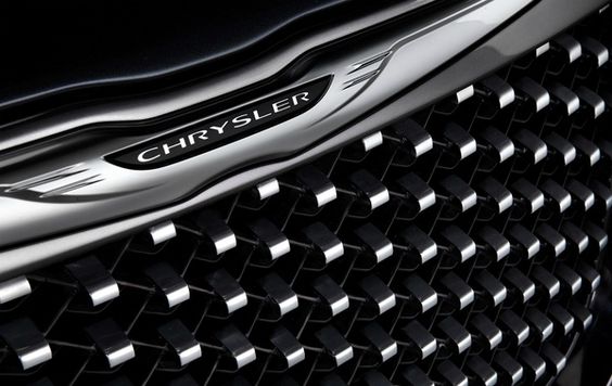 Close-up of Chrysler car grille with logo, showcasing sleek design and intricate details.