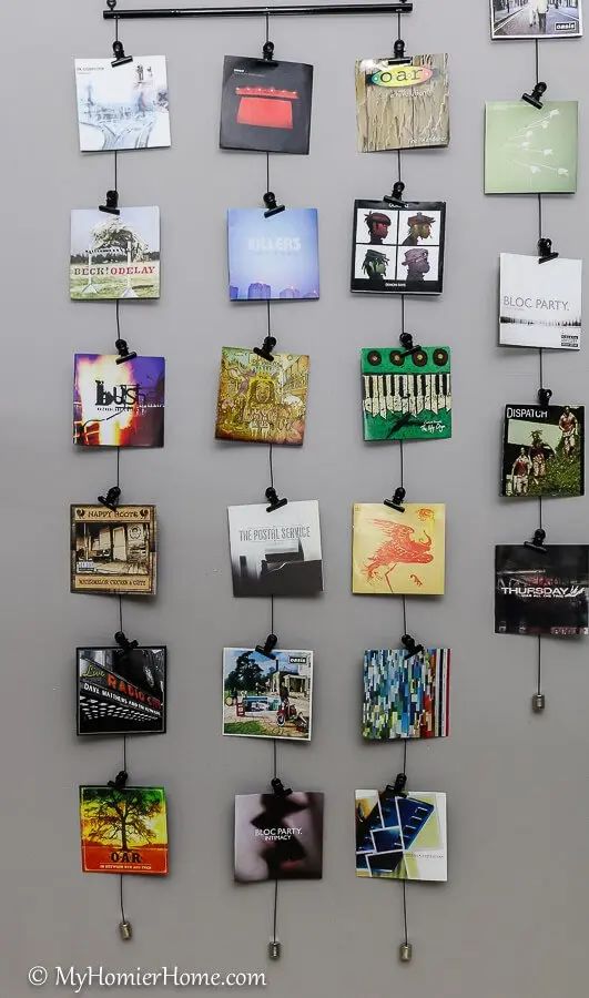 Wall decor displaying album covers in a grid pattern with clips, including covers from O.A.R., Bloc Party, and The Postal Service.