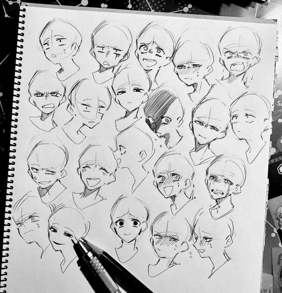 Black and white sketchbook page showing various anime facial expressions, pencil and pen at the bottom right corner for drawing.