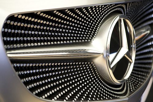 Close-up of a Mercedes-Benz star logo on a stylish car grille, highlighting luxury and automotive excellence.