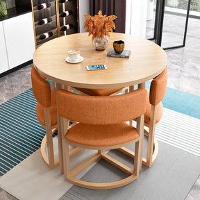 Modern dining room setup with a round wooden table, orange cushioned chairs, and elegant table decor in a contemporary setting.