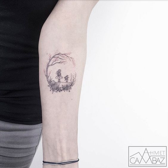 Minimalist tattoo of a girl and plants under a tree on a person's forearm, designed by Ahmet Cambaz.