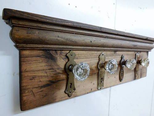 Vintage wooden coat rack with glass knobs, mounted on a white wall, perfect for rustic home decor and storage.