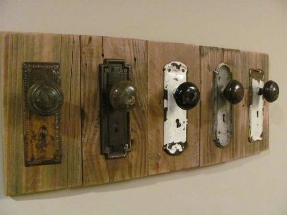 Vintage door knobs mounted on wooden board for rustic home decor.