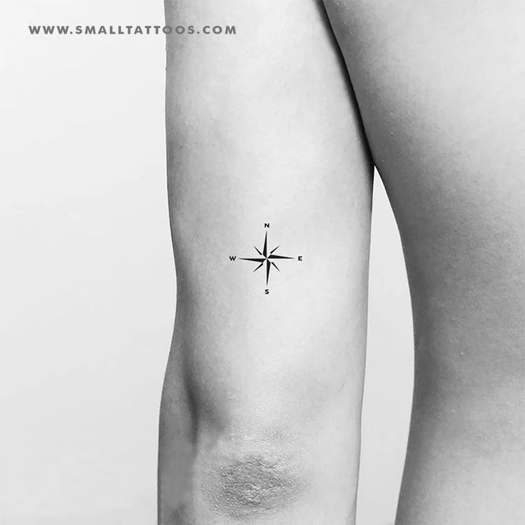 Minimalist compass tattoo on back of upper arm, showcasing simple directional design. Ideal for subtle, meaningful body art.