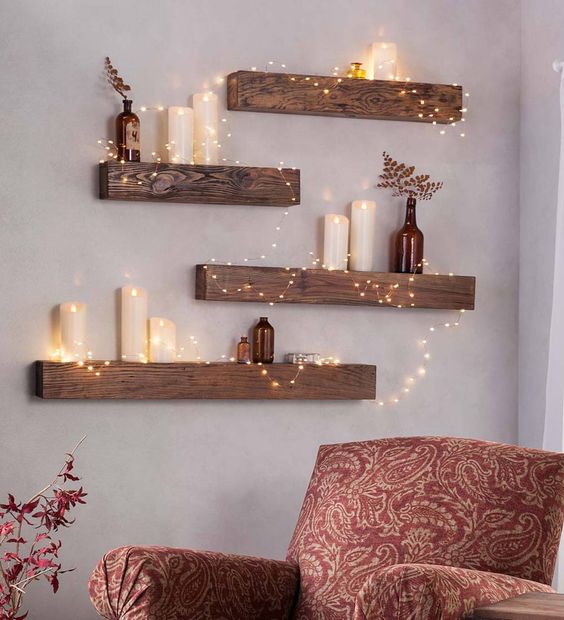 Cozy living room with wooden wall shelves, candles, and fairy lights, creating a rustic and warm ambiance.