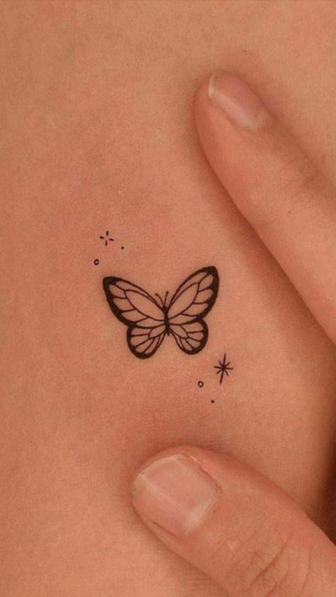 Minimalist butterfly tattoo on skin with stars and dots. Simple black ink design.