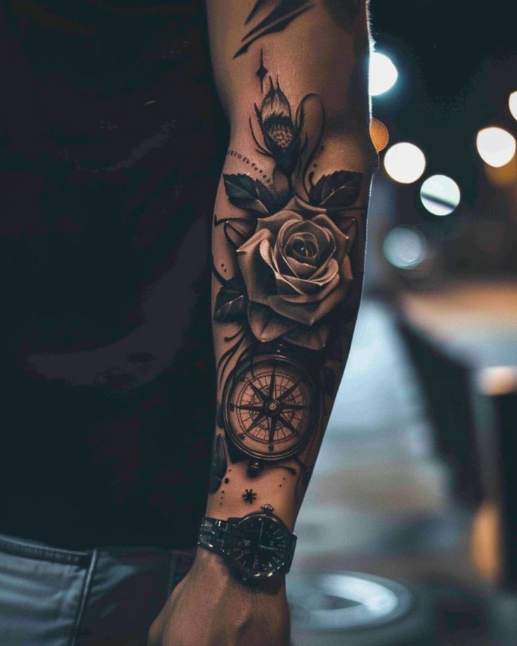 Forearm tattoo featuring a realistic rose and compass design, highlighted in a nighttime setting.