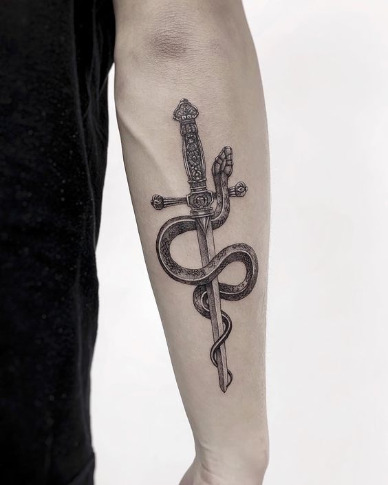 Forearm tattoo of a detailed sword wrapped by a snake, signifying strength and protection, with intricate designs.