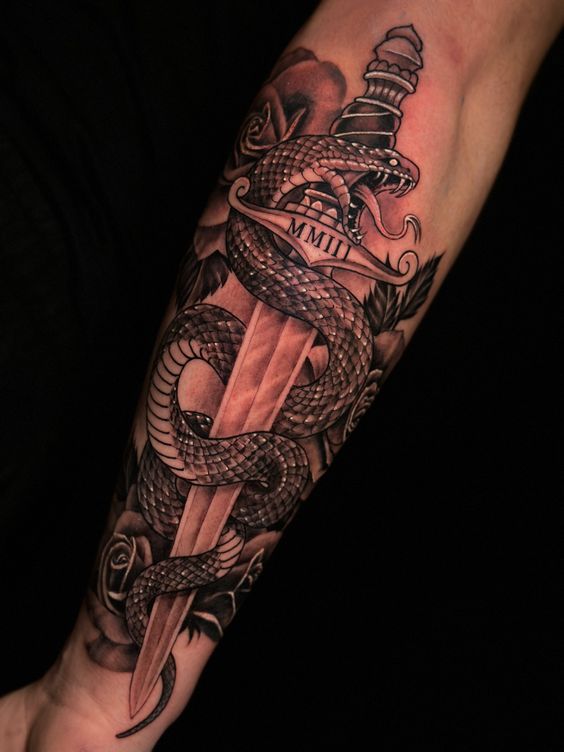 Forearm tattoo of a snake coiled around a dagger with MMIII inscription in black and white.