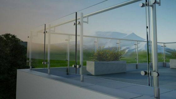 Rooftop terrace with glass railing and scenic mountain view in the background during sunset.