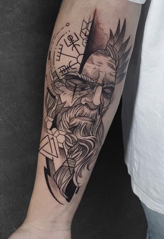 Forearm tattoo depicting a bearded man's face with Norse symbols, intricate lines, and geometric patterns.