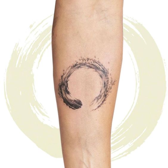 Minimalist Enso circle tattoo on forearm, symbolizing Zen, enlightenment, strength, and elegance.