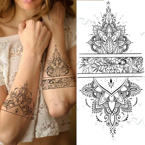 Woman showcasing detailed floral and mandala arm tattoo design with reference sketch beside, wearing a white lace top.