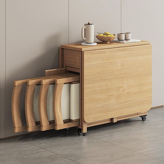 Wooden folding table with retractable stools, perfect for small spaces and minimalist decor, set against a neutral wall.