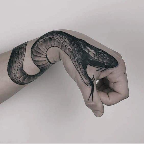 _ 2 Black snake tattoo wrapped around a hand, showcasing detailed scales and realistic design on a light skin background. | Sky Rye Design Black snake tattoo wrapped around a hand, showcasing detailed scales and realistic design on a light skin background.