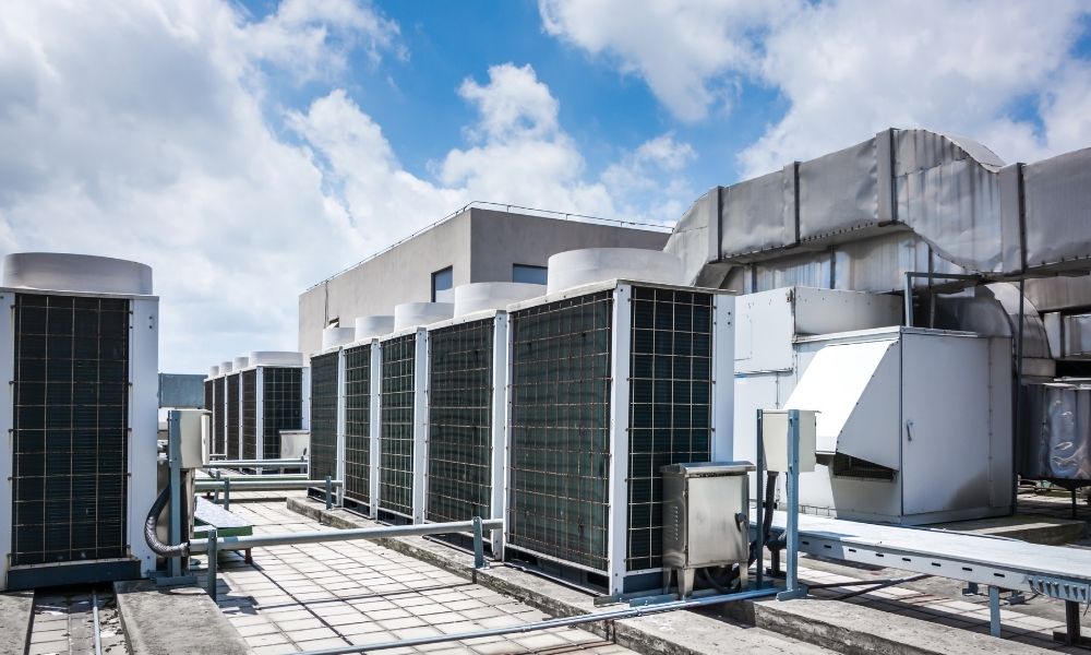 Industrial air conditioning units on a rooftop against a blue sky, providing climate control for the building.