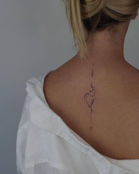 Minimalist abstract back tattoo on woman with an off-shoulder white shirt. Subtle and elegant design on upper back.