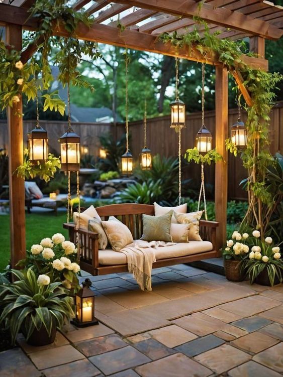 Backyard pergola with hanging lanterns, cozy swing seat, and lush garden flowers, creating a serene evening retreat.