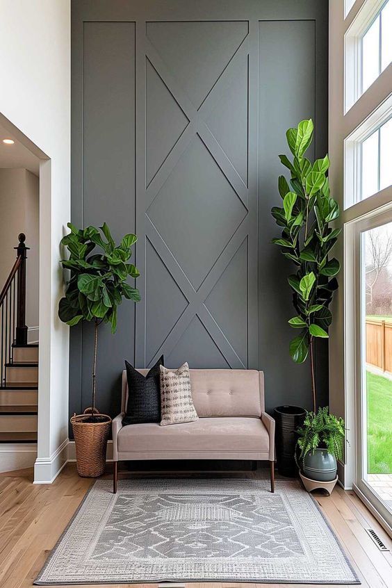 Modern living room interior with gray accent wall, beige sofa, potted plants, natural light, and stylish decor.