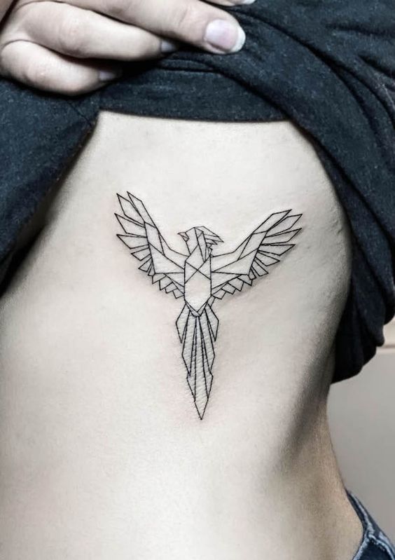 Geometric phoenix tattoo on side rib area, detailed black ink design.