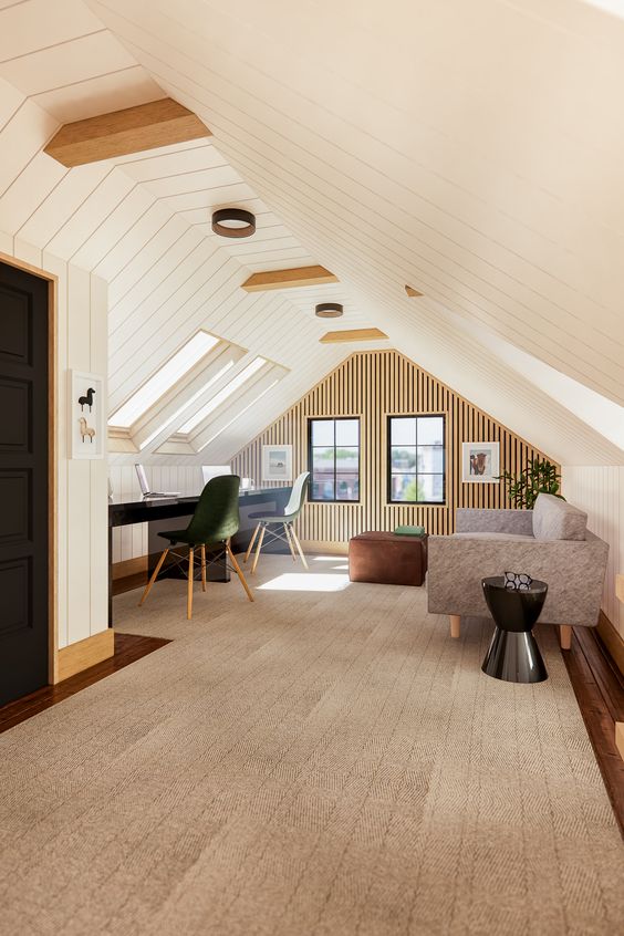 Modern attic space with wooden beams, natural light, cozy seating area, and home office setup with skylight windows.