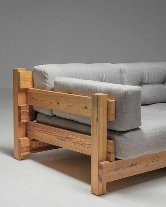 Modern wooden sofa with gray cushion upholstery, featuring a minimalist and sturdy design. Perfect for living room decor.