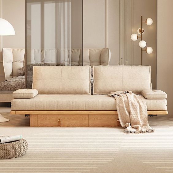 Modern beige sofa with minimalistic design in a cozy living room, accented by a throw blanket and stylish lighting.