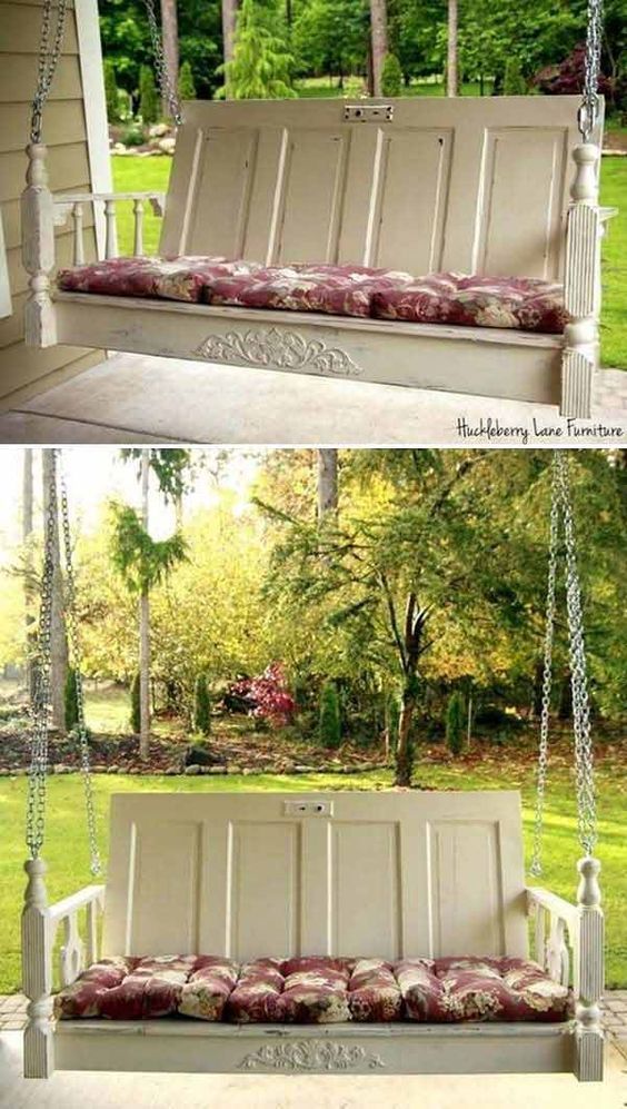 Vintage wooden porch swing with floral cushions, providing a cozy seating area with a scenic view of the garden.