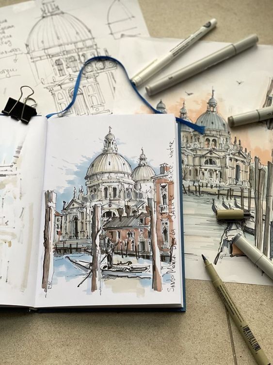 Sketches of an old cathedral with architectural details, drawing tools, and notebooks on a beige desk.