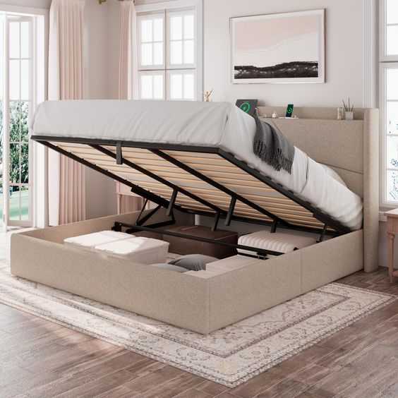 Modern beige bed with storage compartment, open to reveal organized storage space under mattress in elegant bedroom.