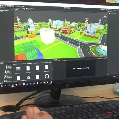 Person developing a colorful virtual city in a 3D software on a computer screen, with detailed interface elements.