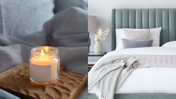 Cozy bedroom with a candle, a plush bed with green headboard, gray and white pillows, and a soft blanket.