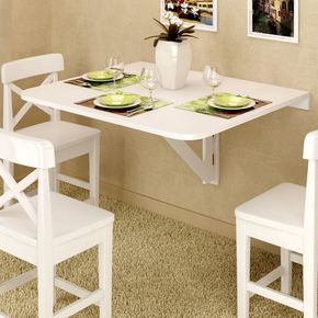 Compact dining area with wall-mounted foldable table, white chairs, and a potted plant centerpiece. Modern and space-saving design.