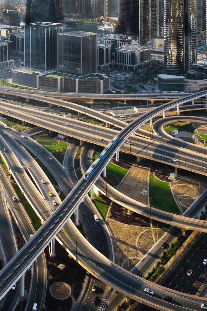 Aerial view of a modern city with intricate highways, skyscrapers, and a train moving on an elevated track.