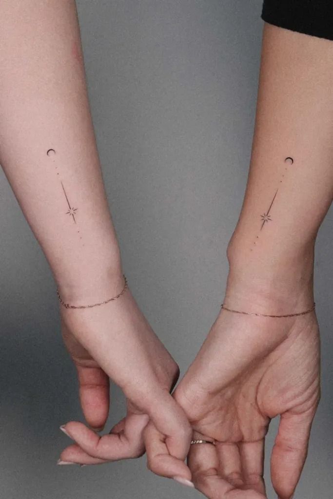 Matching minimalist moon and star tattoos on two forearms, symbolizing connection and balance.