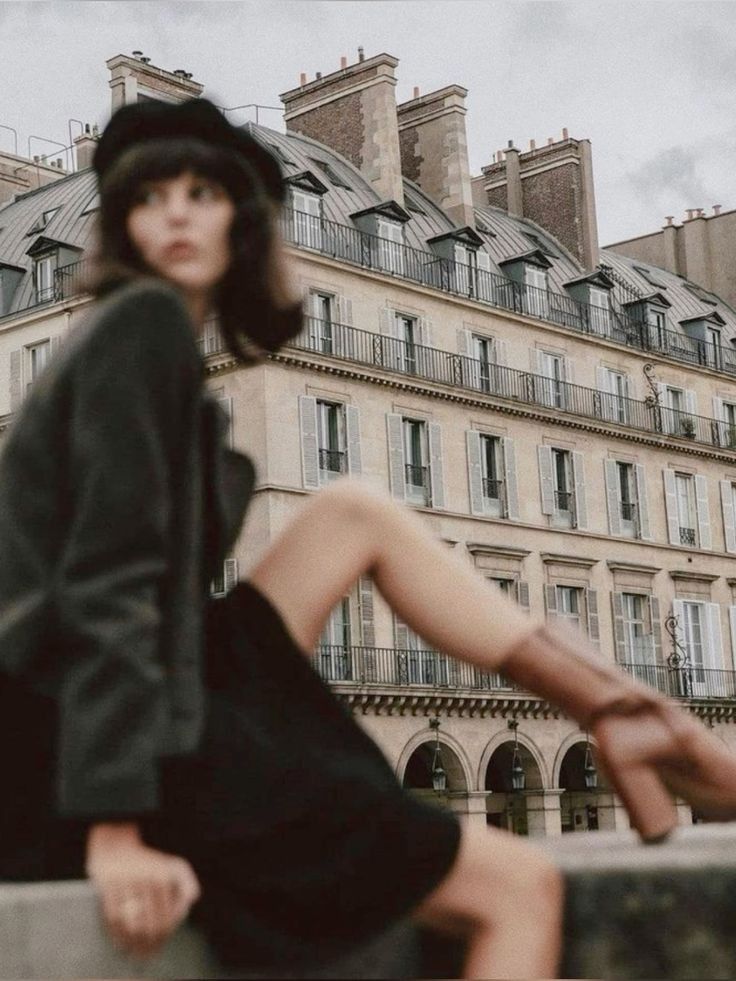 Fashionable woman in front of historic Parisian building, wearing a beret and boots, capturing a chic urban vibe.