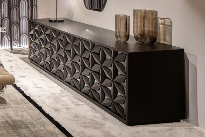 Modern black sideboard with geometric pattern and decorative vases, placed in a stylish, contemporary living room.