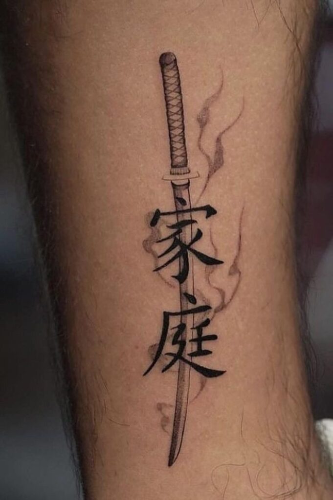 Tattoo of katana sword integrated with Japanese kanji characters on skin, symbolizing strength and heritage.