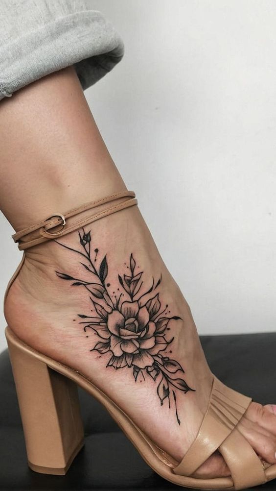 Floral foot tattoo with heels, showcasing intricate flower design on ankle for stylish body art inspiration.