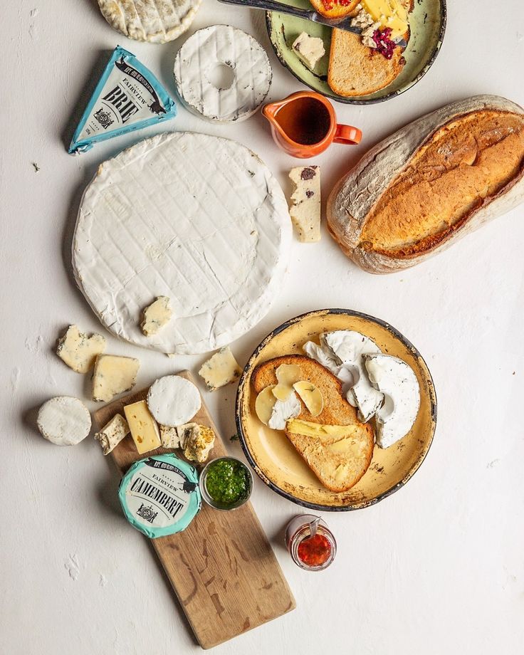 Assorted cheeses, bread, and spreads on a rustic table top view. Perfect for a gourmet snack or appetizer setting.