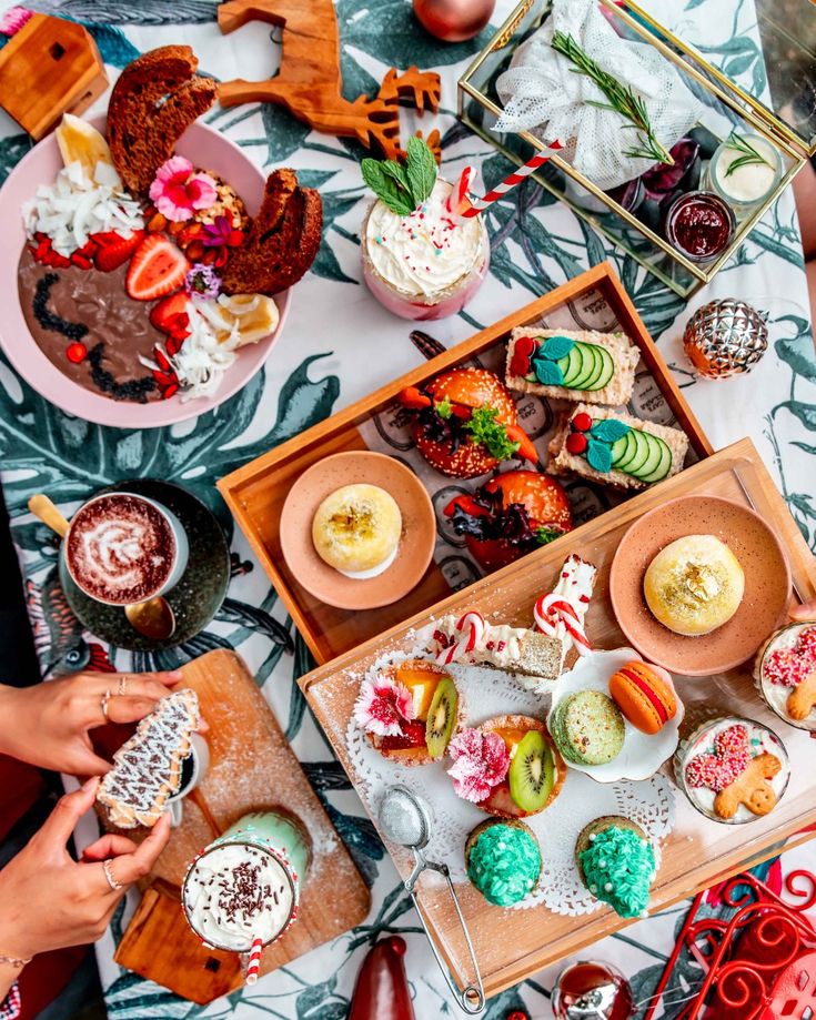 Colorful brunch spread with desserts, fresh fruits, drinks, and pastries on a festive table setting.