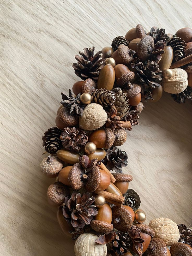 Natural fall wreath with acorns, pinecones, and nuts on a wooden background. Perfect for autumn home decor.