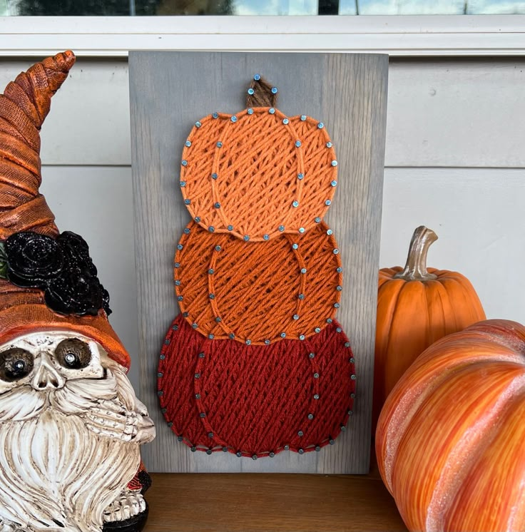 String art pumpkins and a gnome with pumpkins decor for fall display.