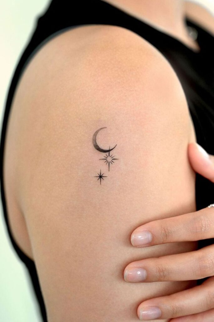 Minimalist crescent moon and star tattoo on upper arm, simple and elegant celestial design.