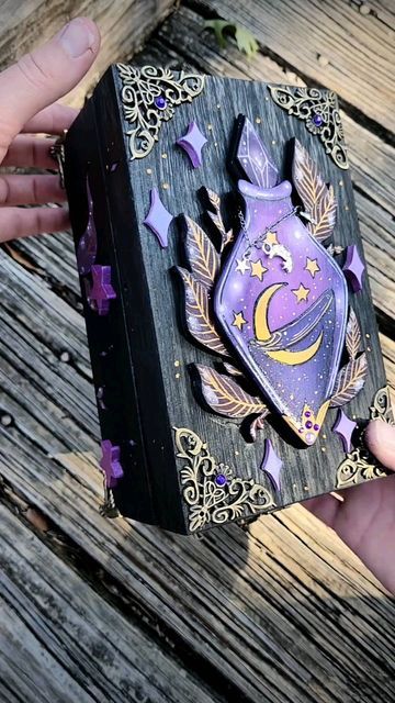 Decorative black and purple box with ornate celestial design featuring stars and a crescent moon.