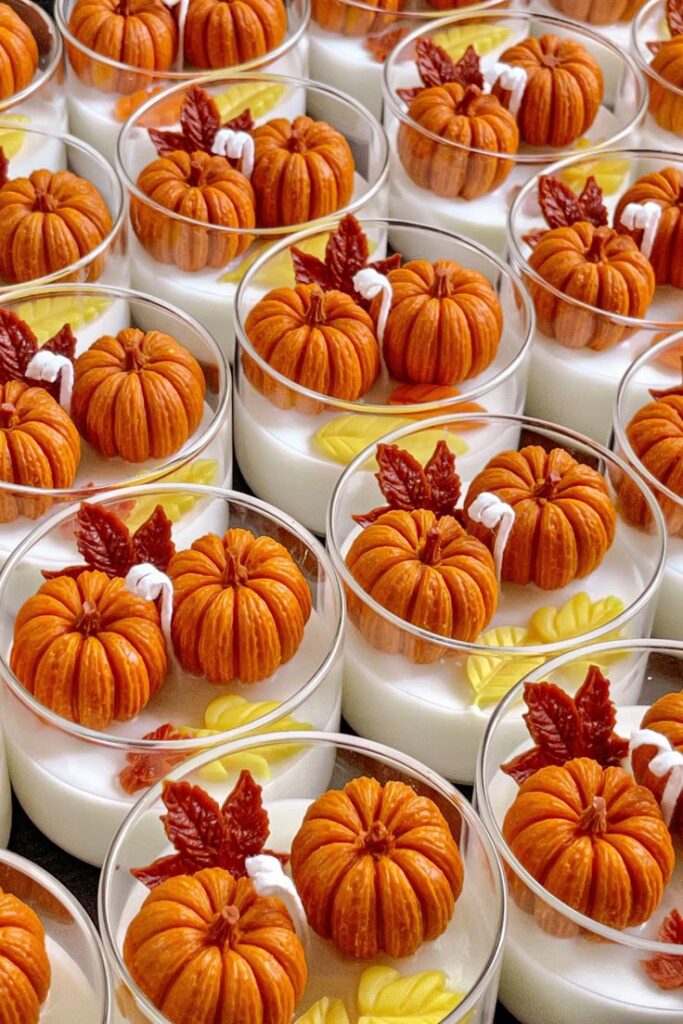 Mini pumpkin desserts in cups with autumn leaf decorations, perfect for fall-themed celebrations and Thanksgiving treats.