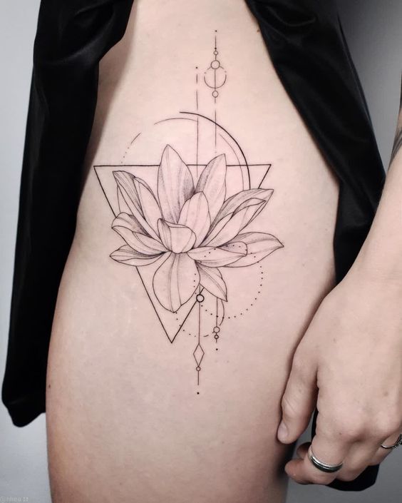 Geometric lotus tattoo design on thigh with intricate linework and circular accents.